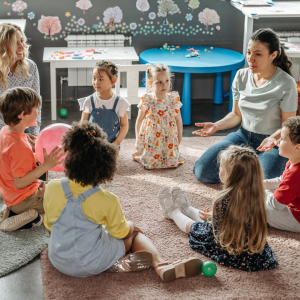 A group of young children sit in a circle with their teaching learning through play to represent this blog about teaching MFL to children with a Spanish language franchise