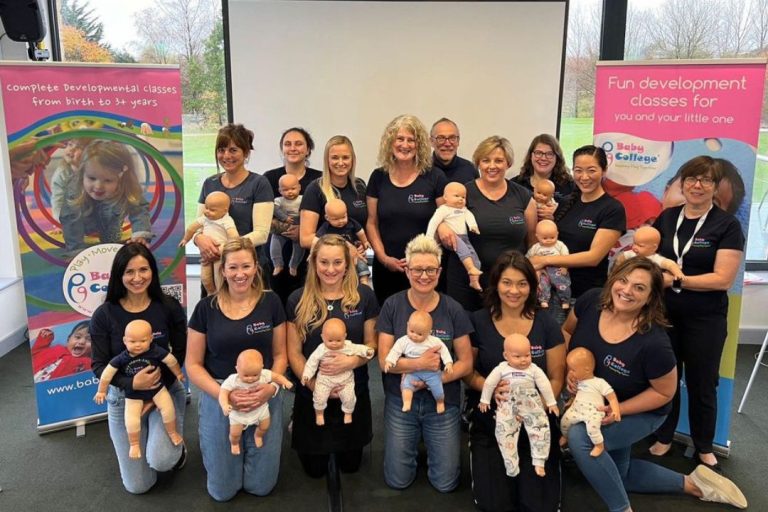 The Baby College franchise team stand together holding their special training baby dolls