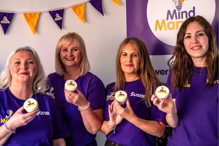 Team photo from mindfulness franchise Mind Marvels as they pose with smiles and branded cupcakes