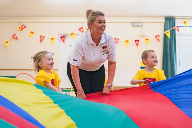 A Tumble Tots class is in full swing with a parachute game for young children