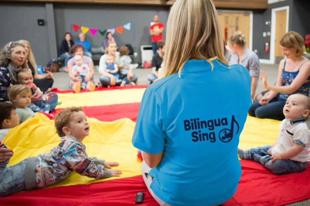 A teacher for BilinguaSing leads a class of young children to learn languages through music