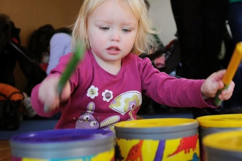 A young girl enjoys playing the drums at a session with Boogie Mites the Music Franchise Business Opportunity UK