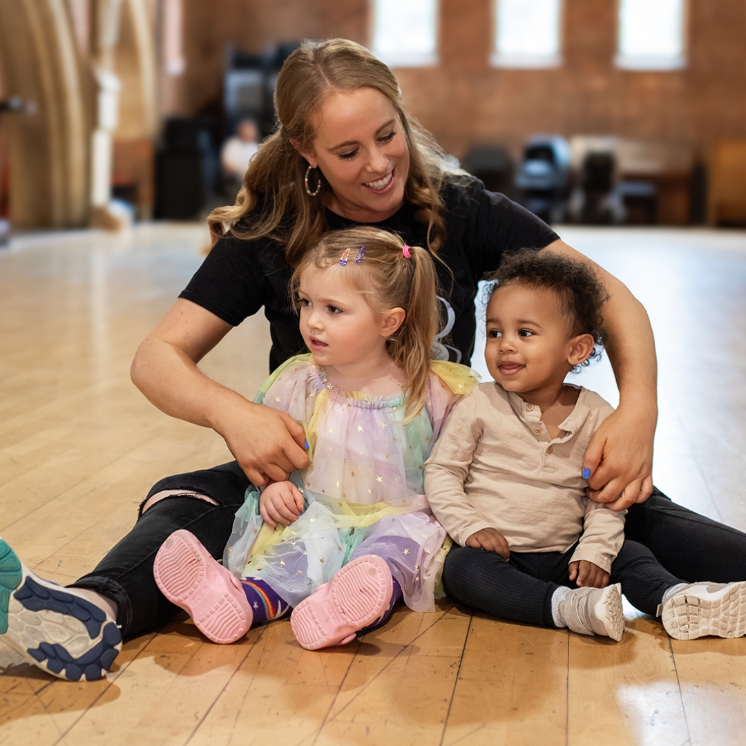 A fun group session at Zip Zap children's franchise with a friendly class leader sitting together with two young children