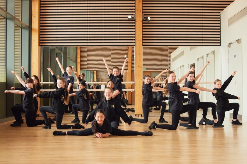 The students at Dance Shack take their final positions for a well rehearsed dance within a studio setting to represent the Dance Shack performing arts franchise