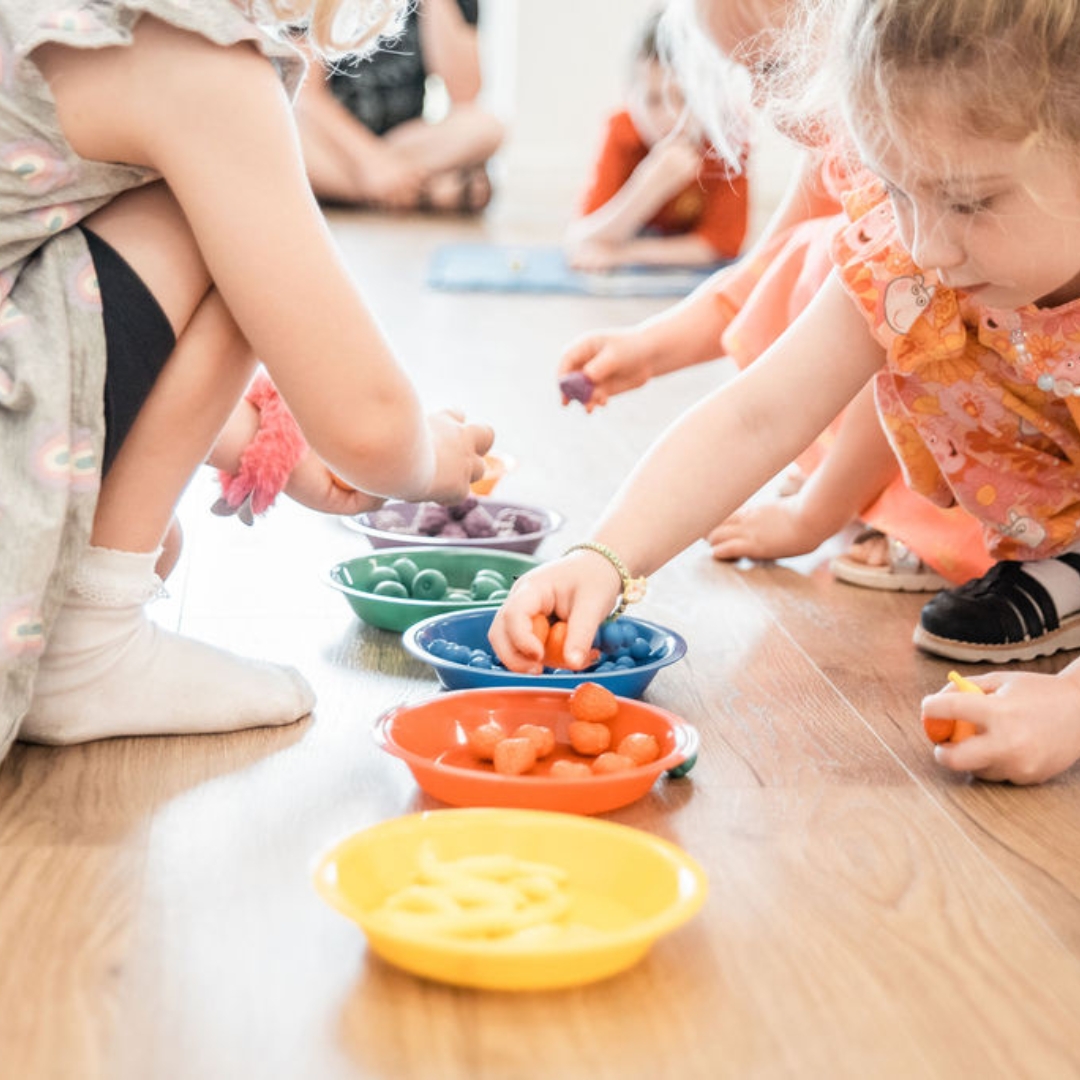 Young children count colourful beads in bowls at a fun session with the unique maths education franchise offering from Counting Kids