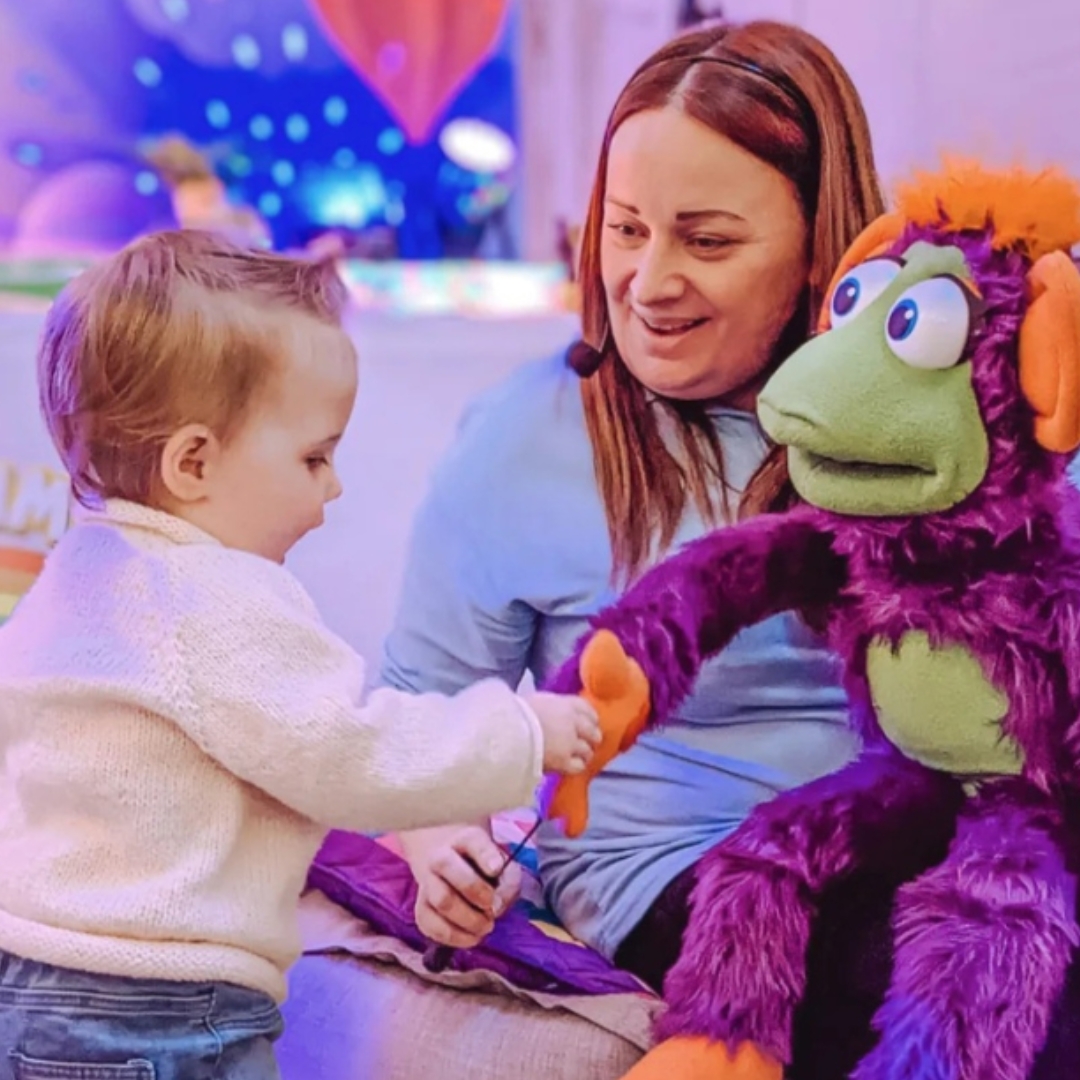 A young child enjoys interacting with a colourful puppet at a sensory session with the Playtimes franchise brand