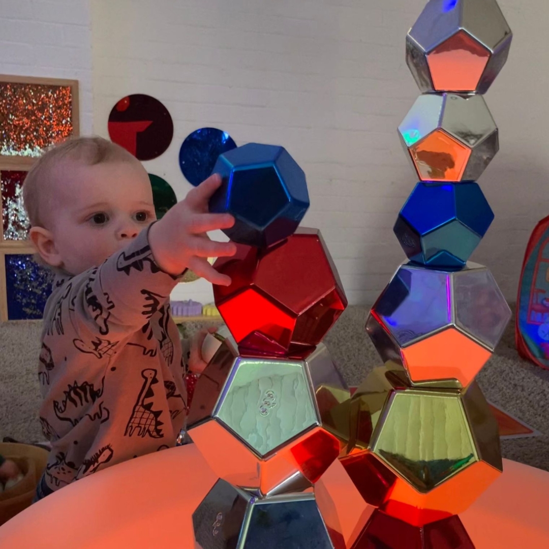 A young child enjoys exploring and playing with colourful shapes at a fun session with the Playtimes sensory franchise brand