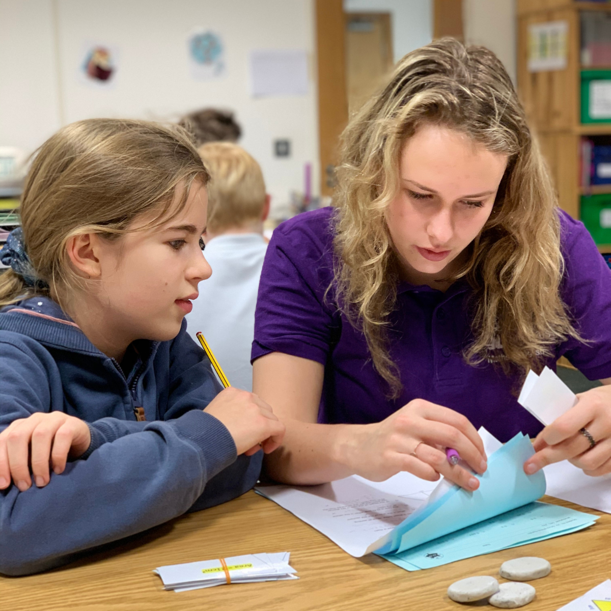 A young girl sits together with a tutor going through her worksheets at an after-school tuition session with education franchise brand MagiKats